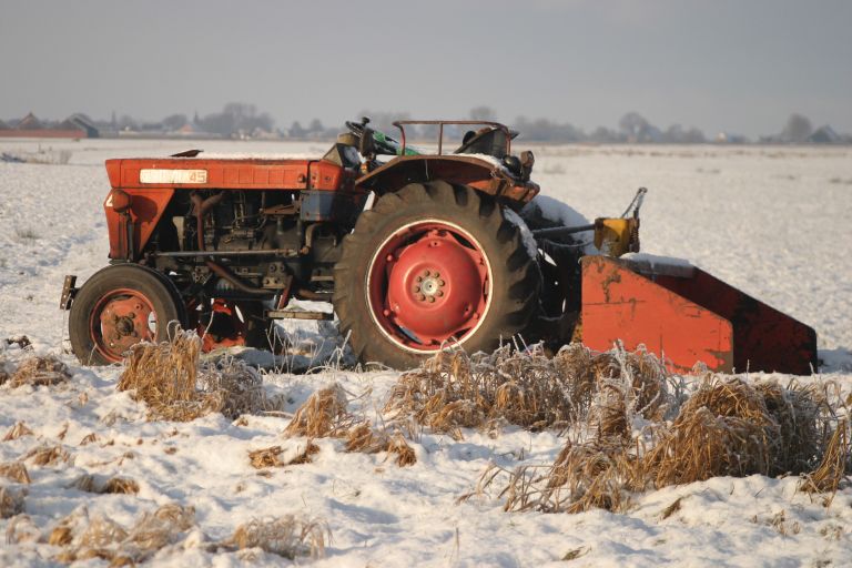 rode trekker in de sneeuw